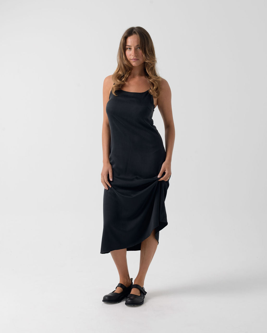 Model wearing the Washed Black Bias Slip Dress in stonewashed stretch silk, highlighting its fluid drape and bias cut.