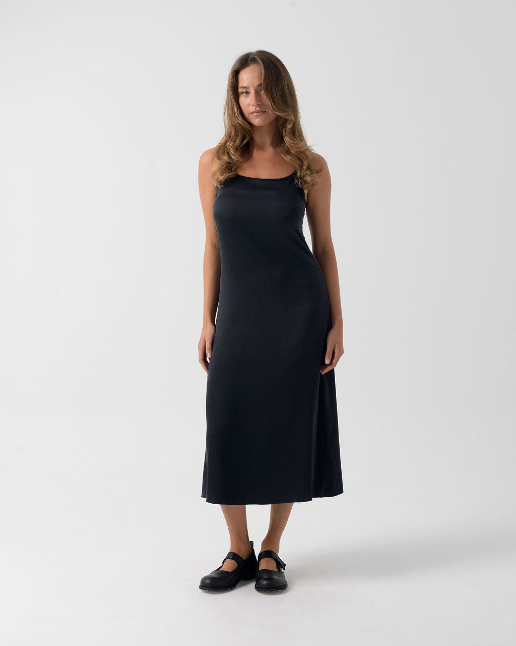 Model wearing the Washed Black Bias Slip Dress in stonewashed stretch silk with a fluid bias-cut silhouette.