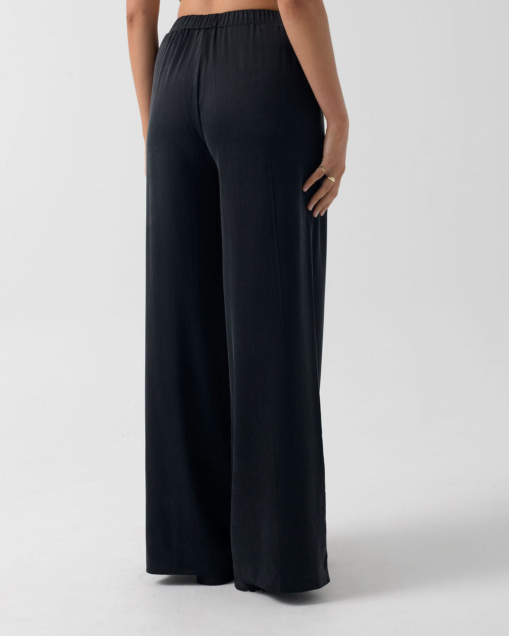 Back view of the Washed Black Classic Wide Leg Pant in stonewashed stretch silk with a relaxed wide-leg silhouette.