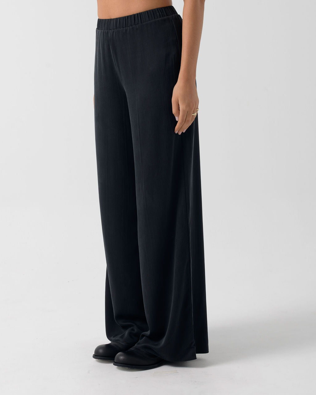 Side view of the Washed Black Classic Wide Leg Pant with a fluid drape and clean, pocket-free silhouette.