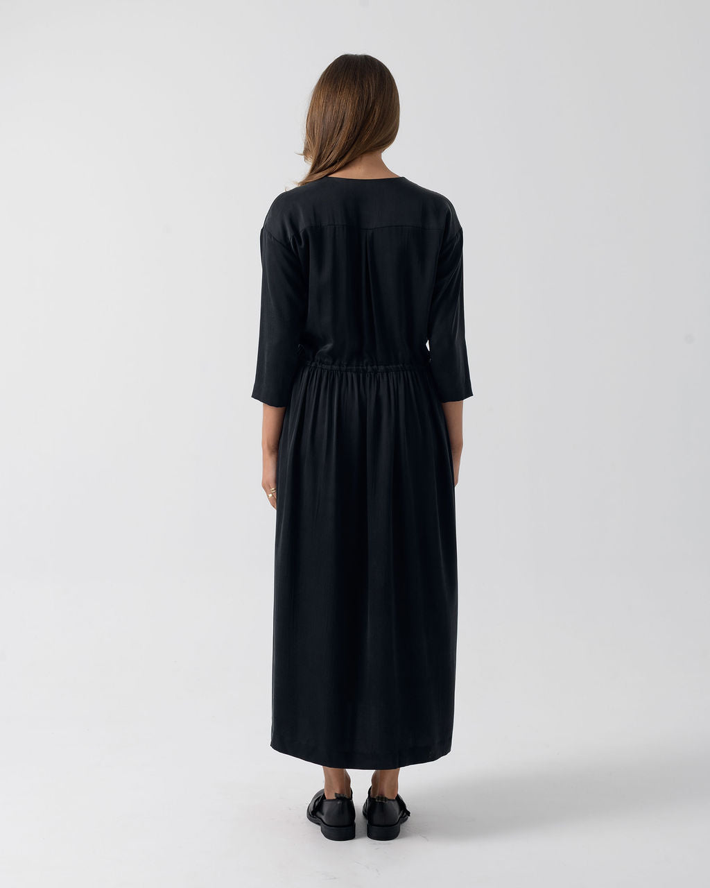 Full back view of the Washed Black Drawstring Dress in stonewashed stretch silk with a relaxed silhouette and three-quarter sleeves.