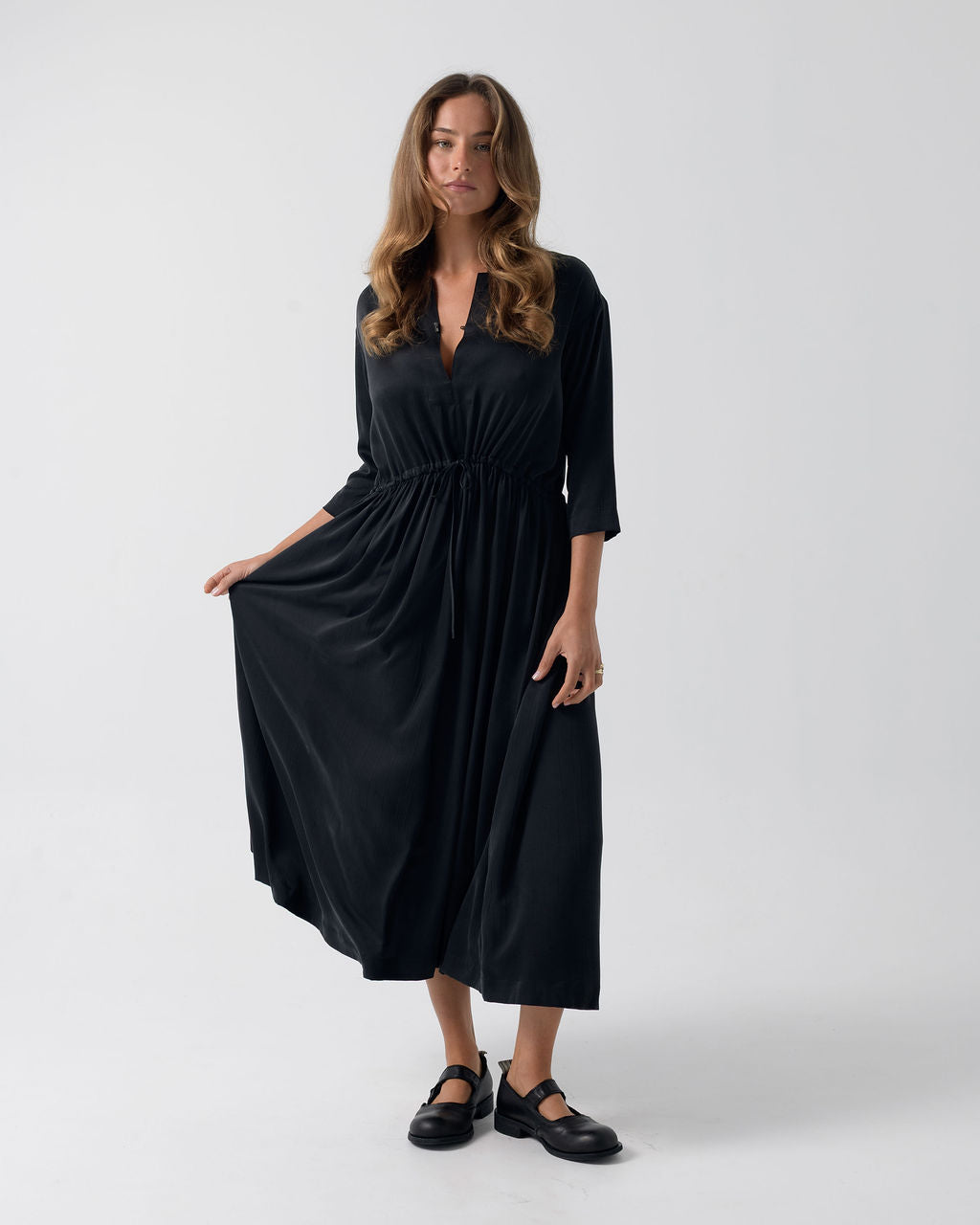 Model wearing the Washed Black Drawstring Dress in stonewashed stretch silk with a cinched waist and fluid full-length silhouette.