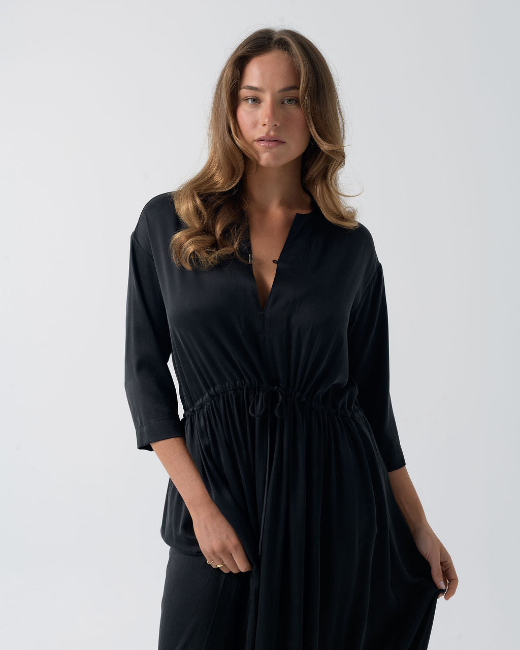Model wearing the Washed Black Drawstring Dress featuring a crew neckline, three-quarter sleeves and adjustable drawstring waist.