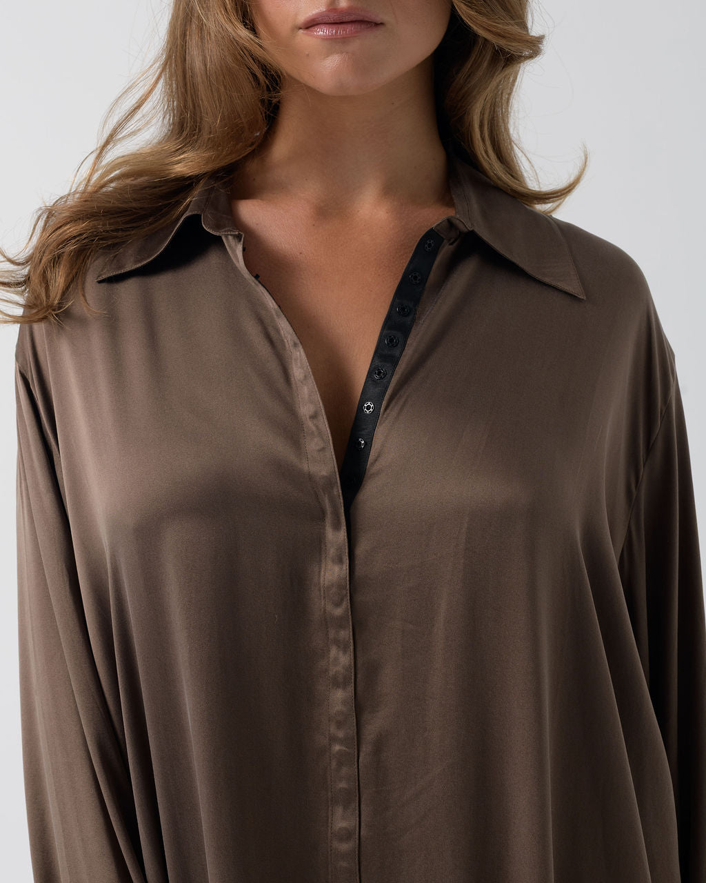 Close-up of the Hazelnut Oversized Silk Shirt featuring the collar, press-stud closure and stretch silk fabric.