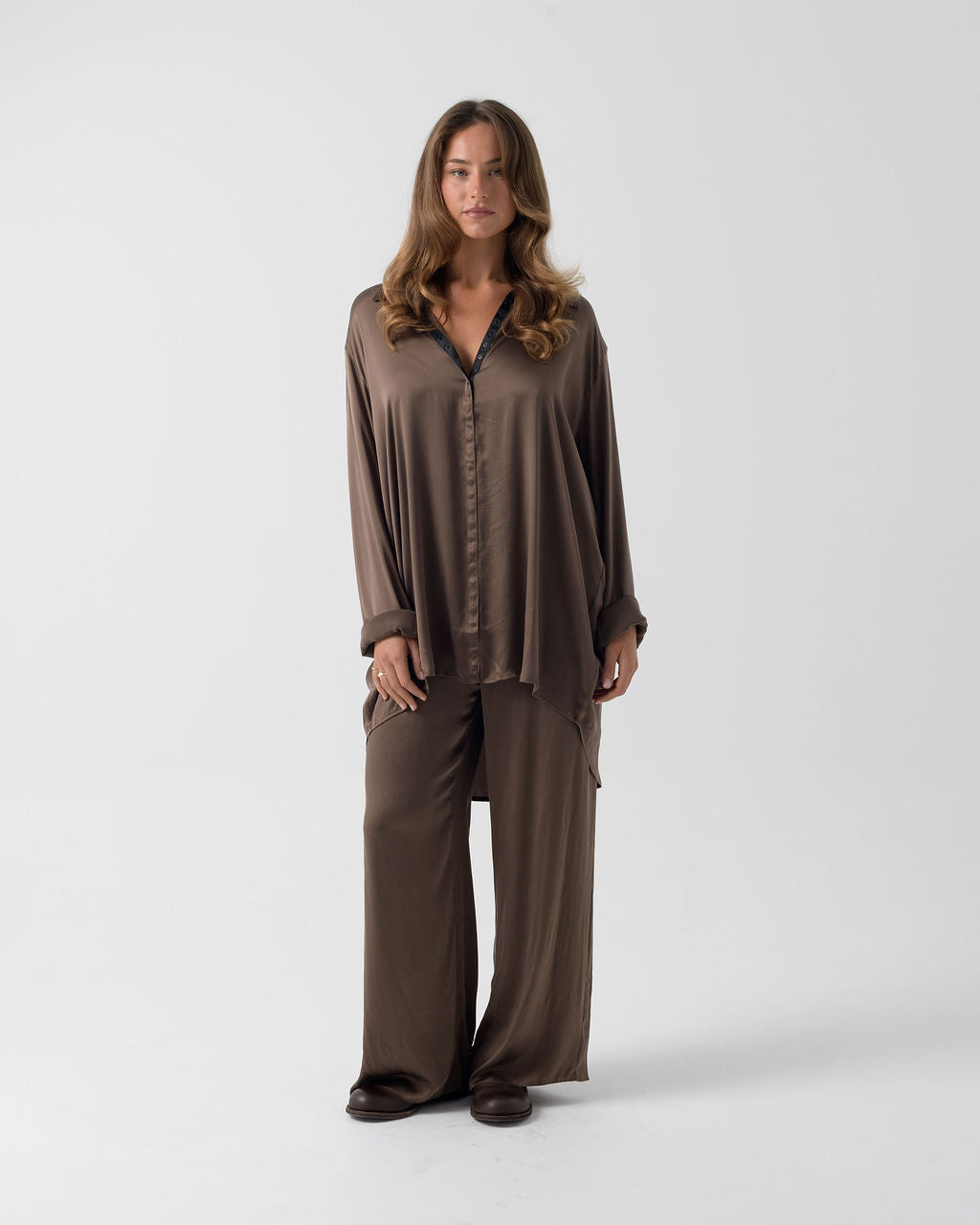 Model wearing the Hazelnut Oversized Silk Shirt in stretch silk with a relaxed silhouette and press-stud closure.