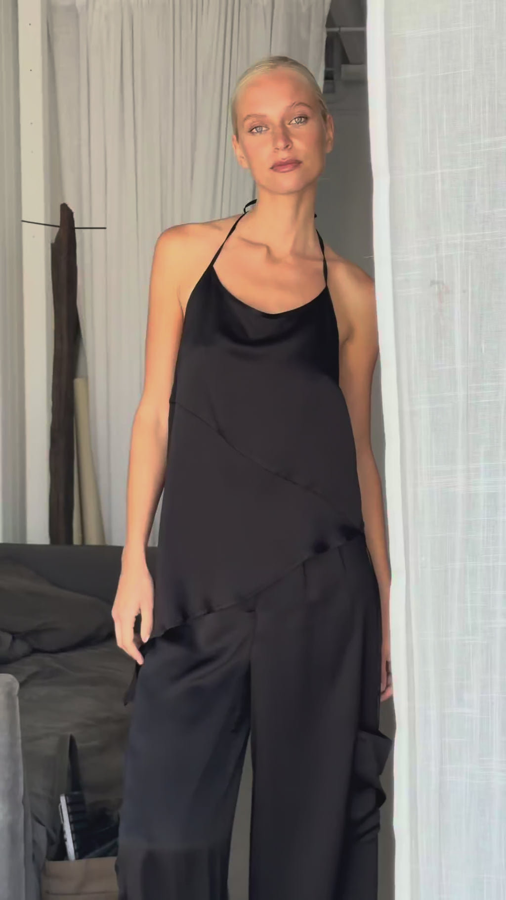 Video showing the asymmetrical tie tank in hammered silk styled with cargo trousers, demonstrating the adjustable tie shoulder, versatile halter styling, and fluid drape.
