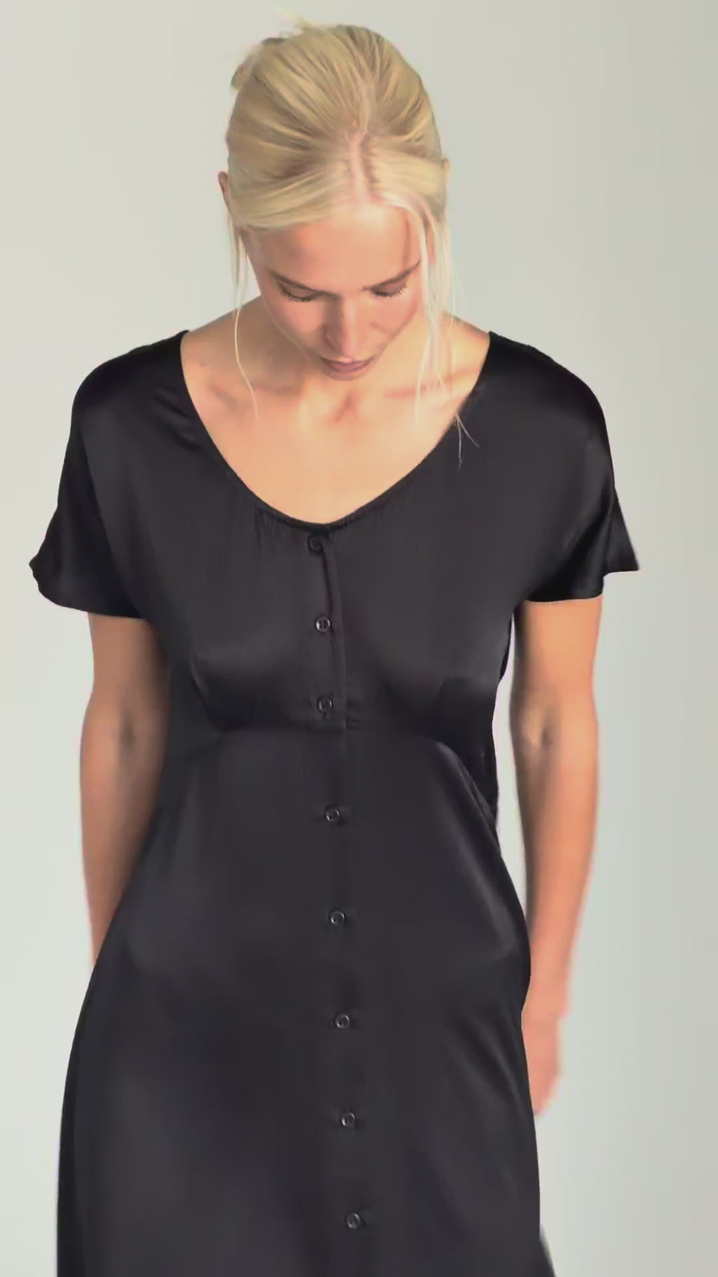 Video showing the Johanna tie dress in hammered silk worn by model Katia, demonstrating the adjustable tie waist, ceramic button detailing, and fluid drape of the lightweight fabric.