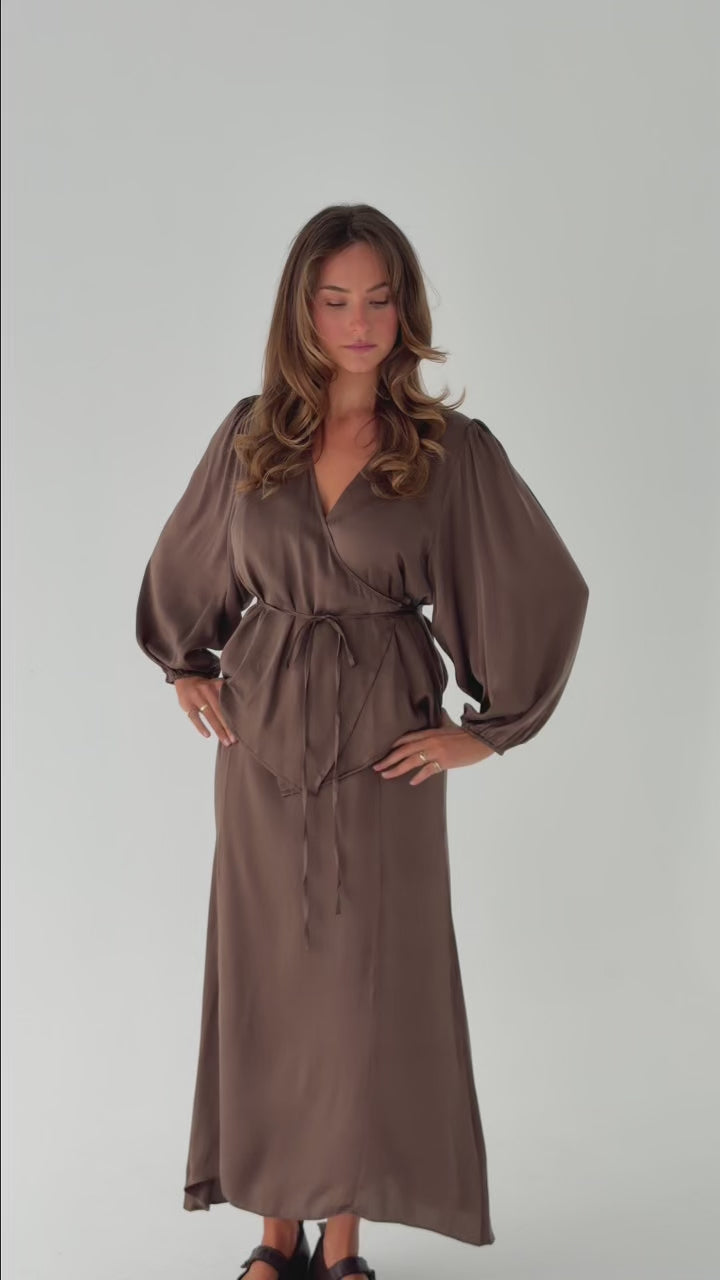 Model wearing the Wrap Blouse in stonewashed stretch silk with billowed sleeves, a wrap silhouette and a fluid, elegant drape.