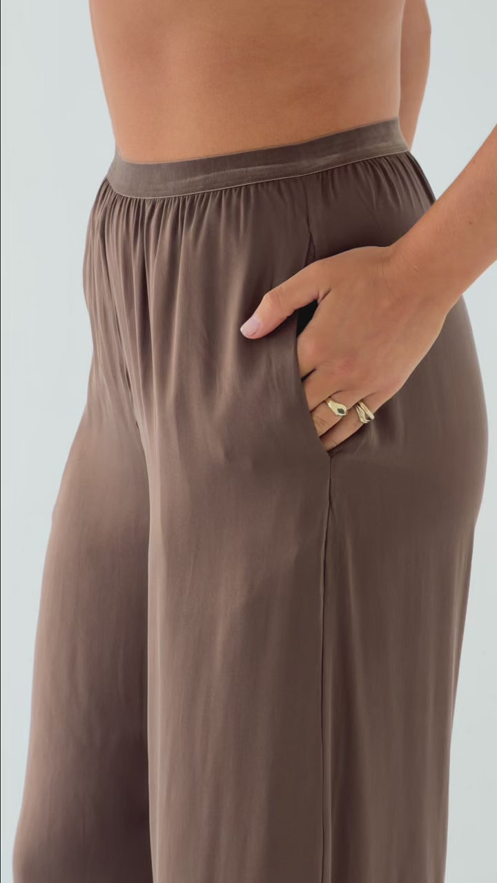 Model wearing the Moka Straight Leg Pant in stonewashed stretch silk with a velvet elastic waistband, side pockets and a relaxed straight-leg silhouette.